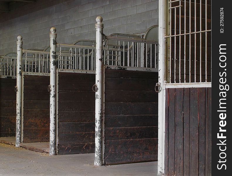 Close-up of empty horse stalls inside a building.