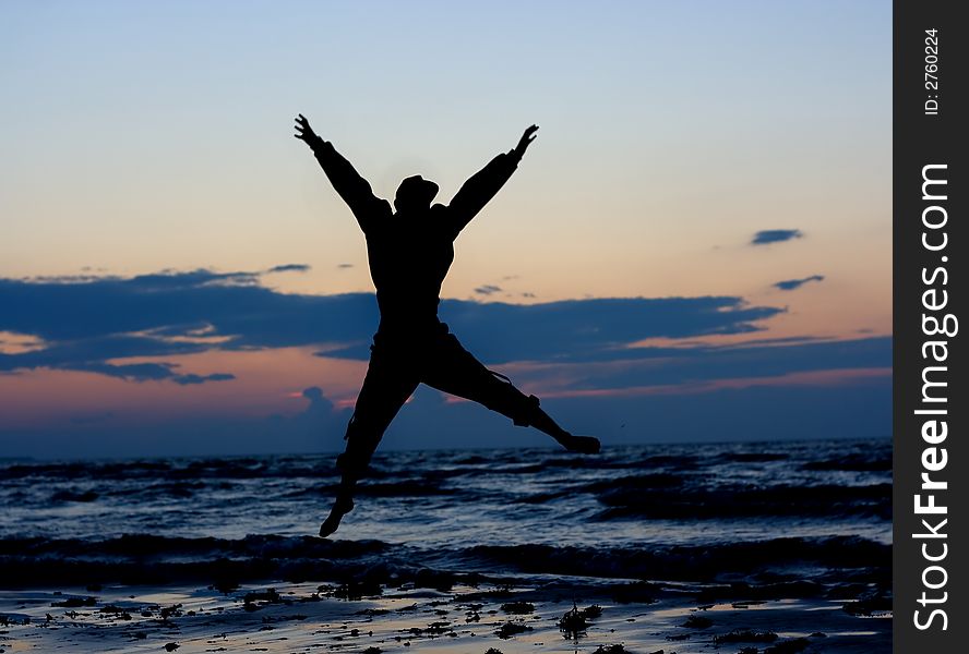 Man jumping near sea at sunset. Man jumping near sea at sunset.