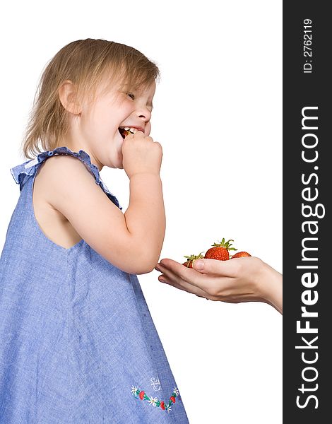 The girl eats a strawberry on an isolated background