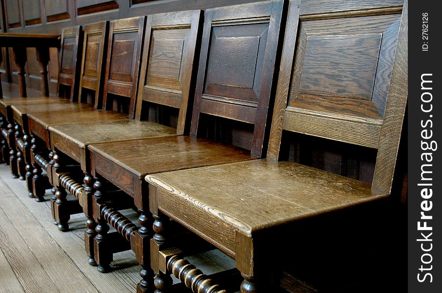 Neat old, antique church chairs in a row. Neat old, antique church chairs in a row.