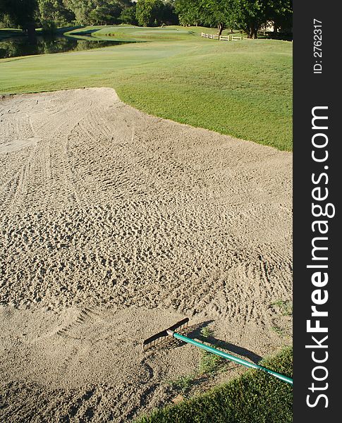 Golf fairway, lake, sand trap and rake. Golf fairway, lake, sand trap and rake.