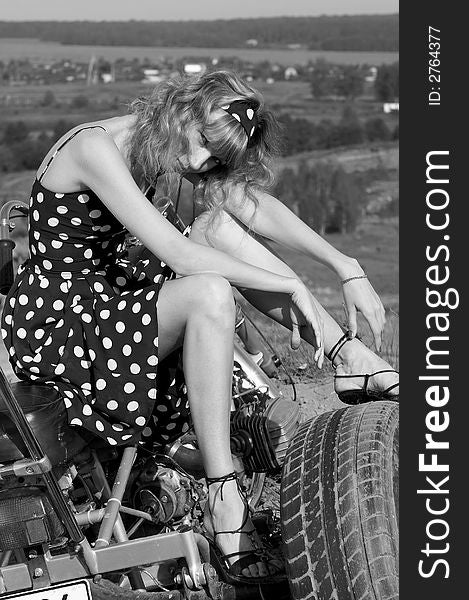 Woman in a retro dress on a motor bike
