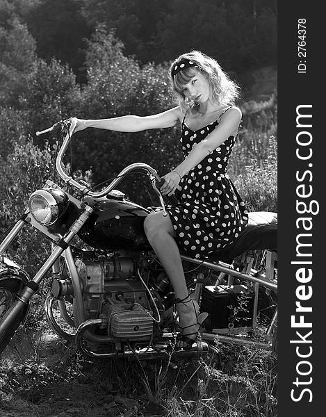 Woman in a retro dress on a motor bike