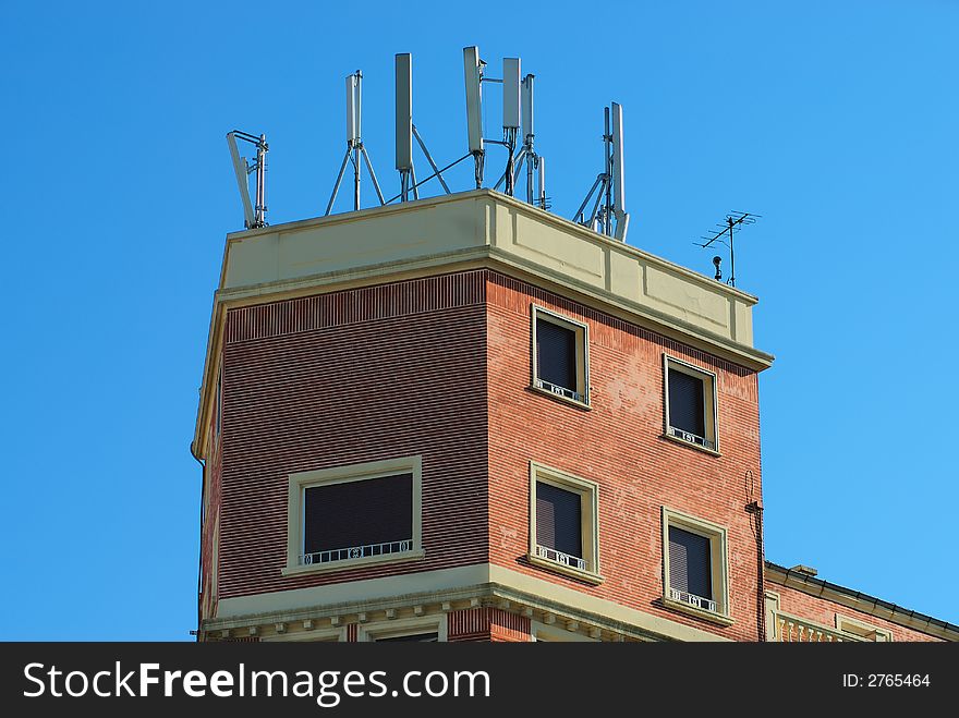 A cell phones aerial on a building roof. A cell phones aerial on a building roof
