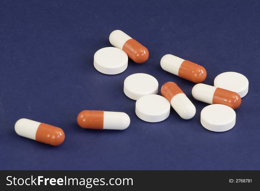 Mixed medical tablets on a blue background. Mixed medical tablets on a blue background
