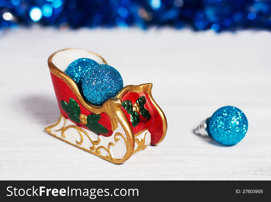 Christmas sleigh with blue balls on rusty white background
