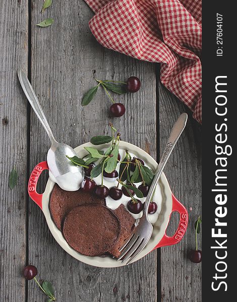 Chocolate pancakes with fresh cherries and vanilla sour cream in a bowl