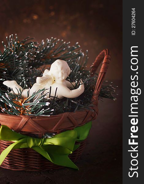 Christmas decoration with little cute angel in a wicker basket