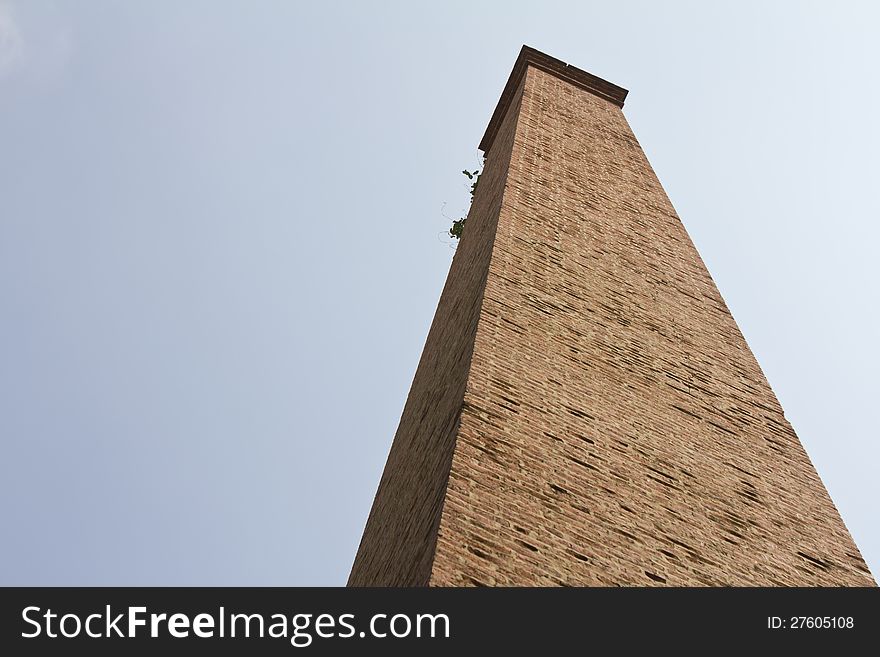 Isolates of the old brick chimney with a large grass growing on the end of it. Isolates of the old brick chimney with a large grass growing on the end of it.