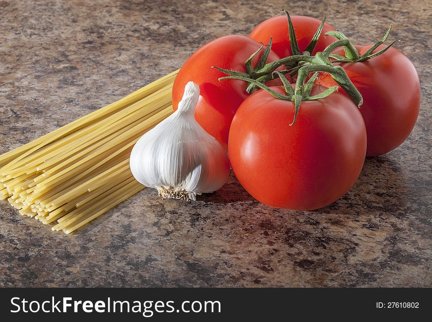 Tomato, pasta and garlic on kitchen table. Tomato, pasta and garlic on kitchen table.