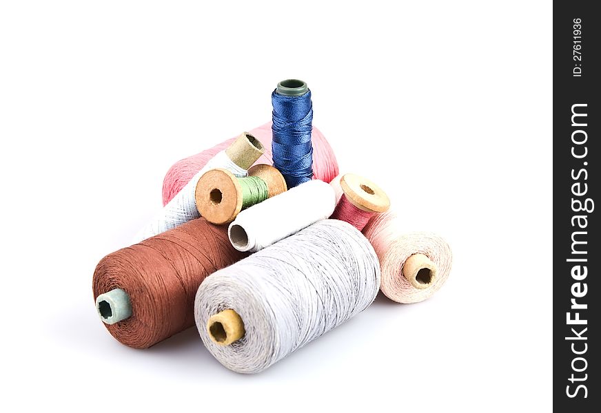 Several cones of thread of different colors on a white background. Several cones of thread of different colors on a white background