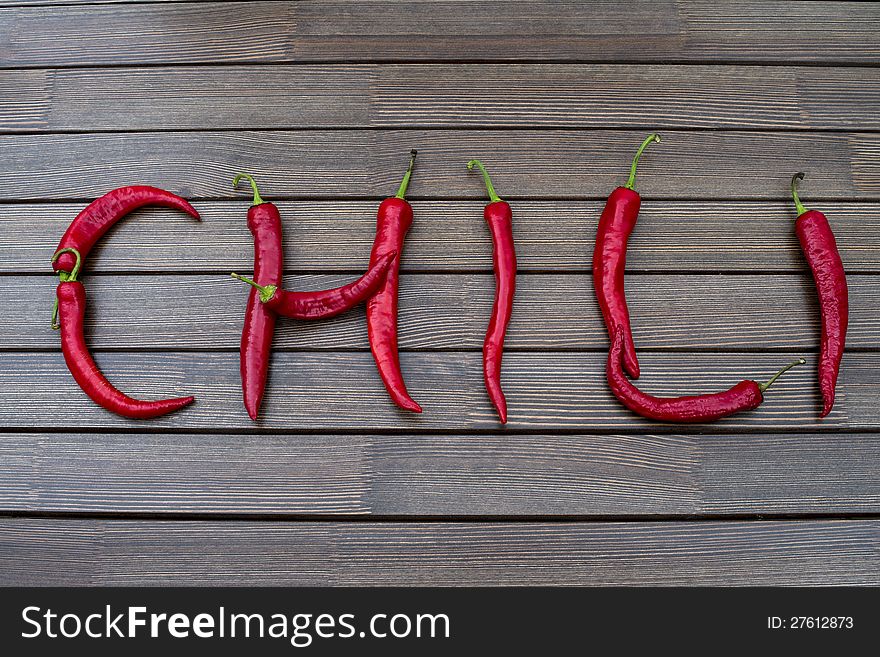 The word Chili on a brown table from hot red peppers of Chile