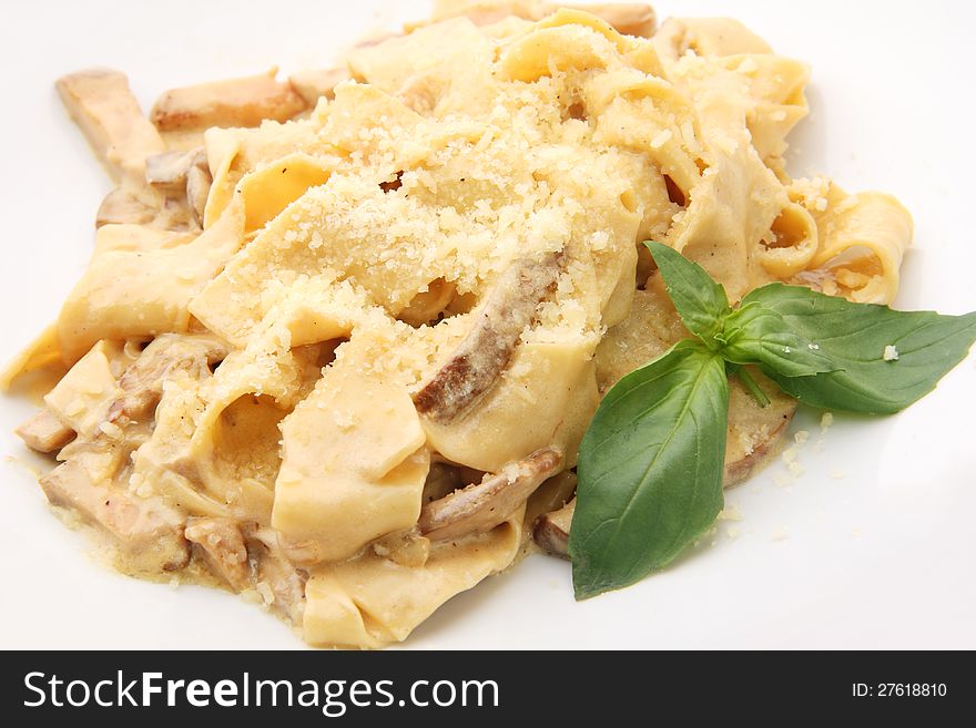 Papardelle with mushrooms in cream sauce with mint leafs  on white background. Papardelle with mushrooms in cream sauce with mint leafs  on white background