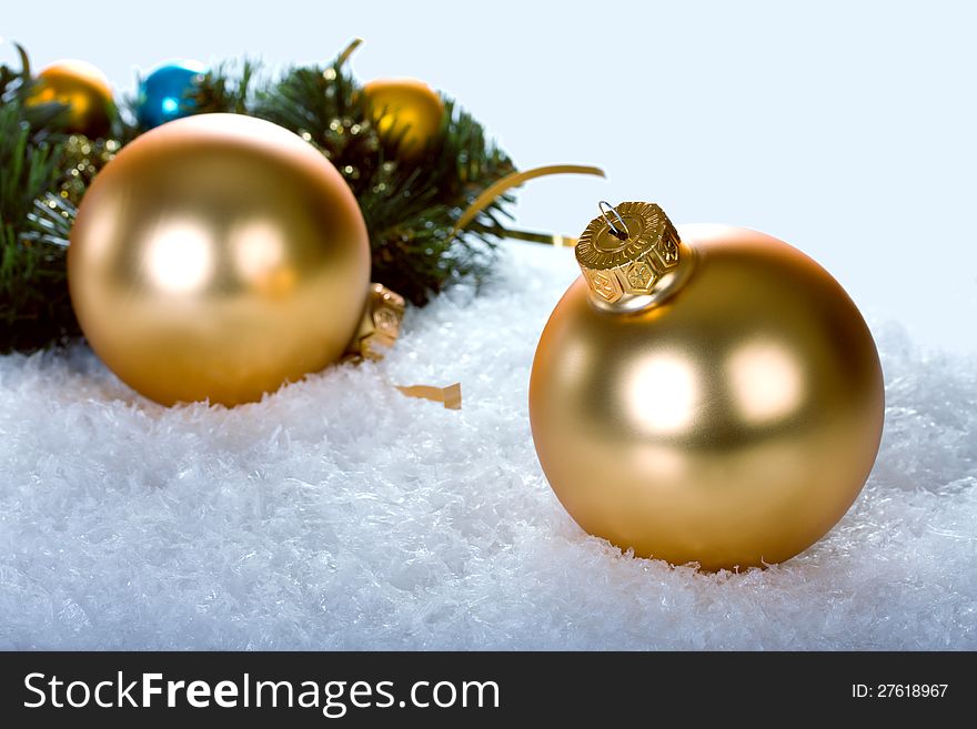 Golden christmas balls with branch christmas tree on blue snow