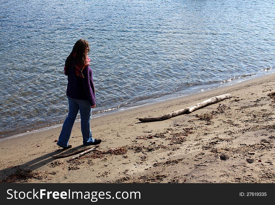 Brunette woman walking along empty beach