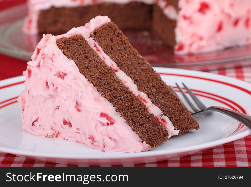 Piece of chocolate cake with cherry frosting on a plate. Piece of chocolate cake with cherry frosting on a plate