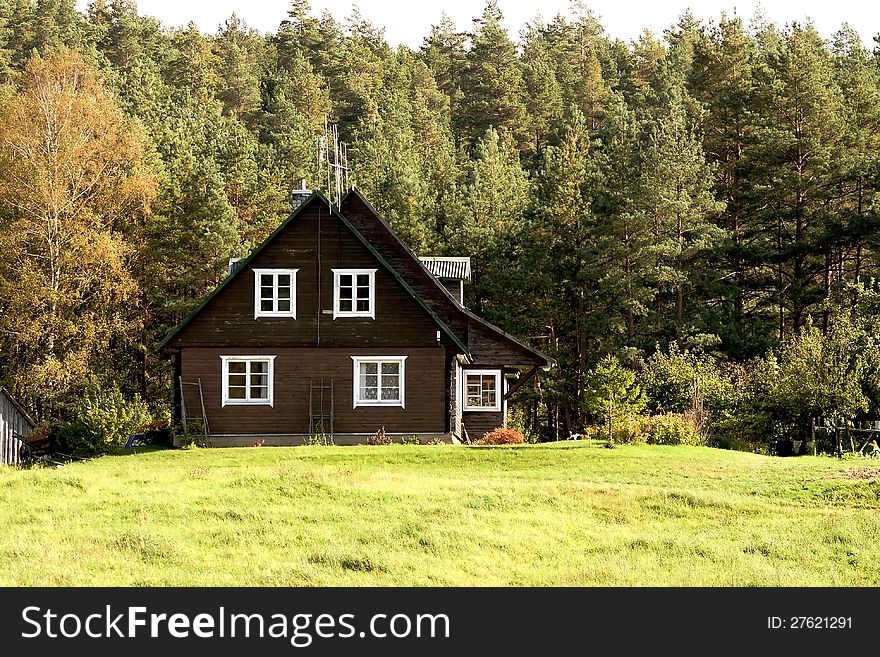 Rural landscape-old small wooden cottage next to the coniferous forest. Rural landscape-old small wooden cottage next to the coniferous forest