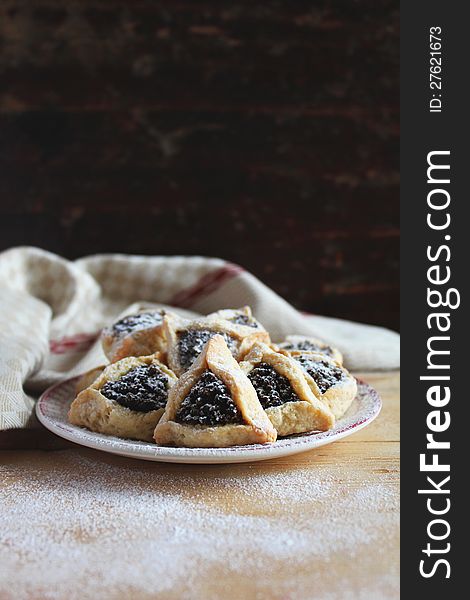 Cookies with date and poppy seed filling on a plate for a Jewish holiday Purim