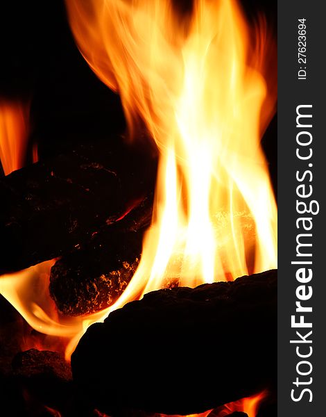 Logs burning brightly in a fire pit is great on a cool night, at home or camping. Logs burning brightly in a fire pit is great on a cool night, at home or camping.