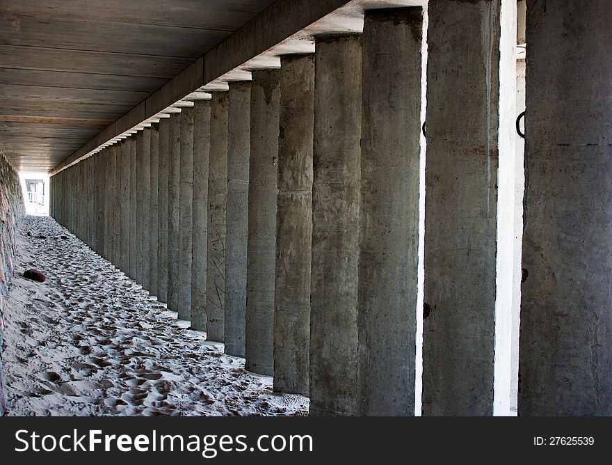 Empty corridor of concrete columns in the city beach