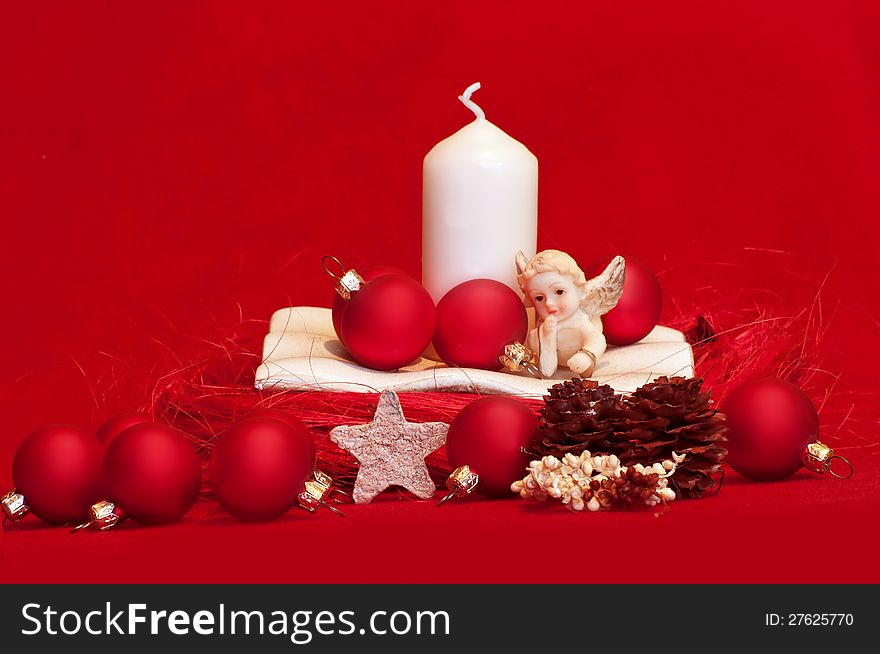 White candle and red christmas balls on red background. White candle and red christmas balls on red background
