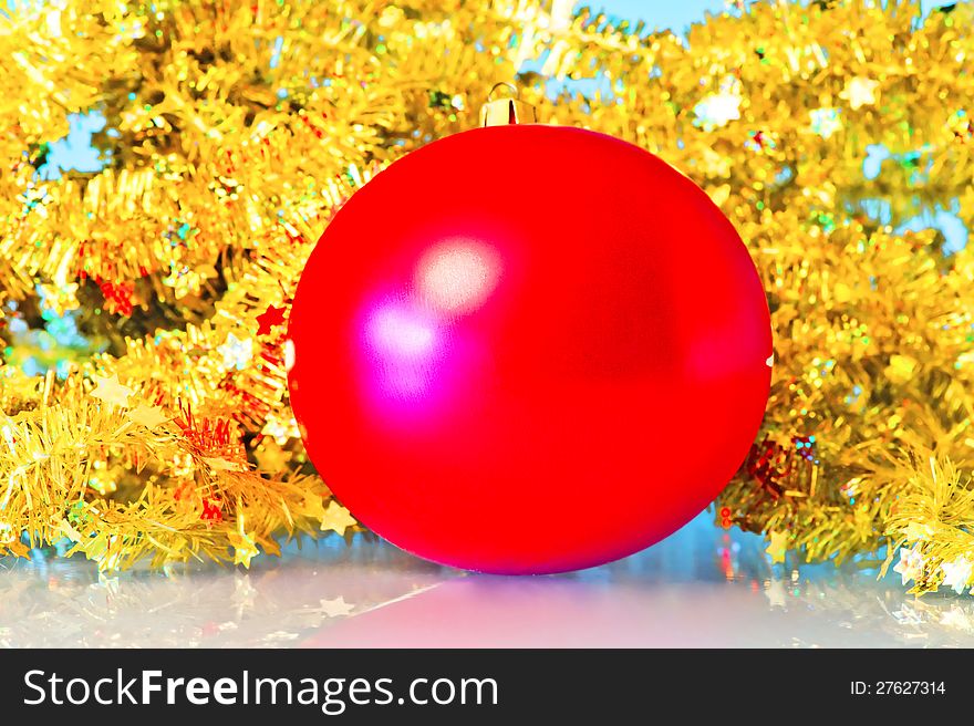 Red Christmas ball in a golden tinsel