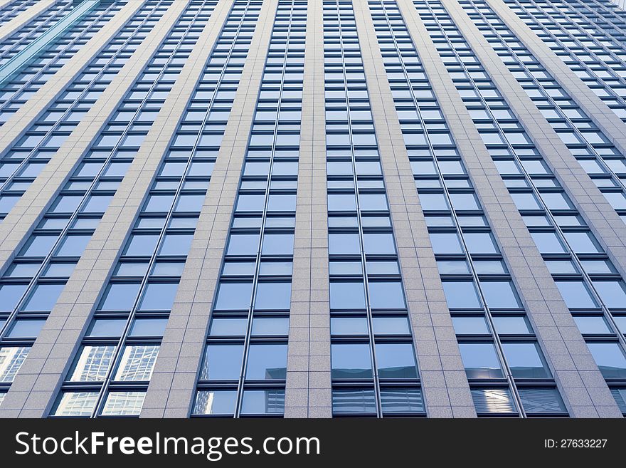 Modern skyscraper building facade with opposite building reflection in windows. Modern skyscraper building facade with opposite building reflection in windows