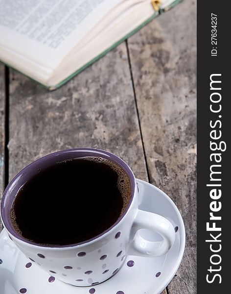 Cup of coffee and book on a wooden table. Cup of coffee and book on a wooden table