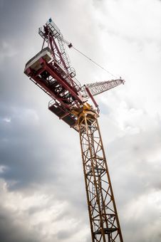 Yellow Tower Crane On Building Top With Blue Sky Stock Photo