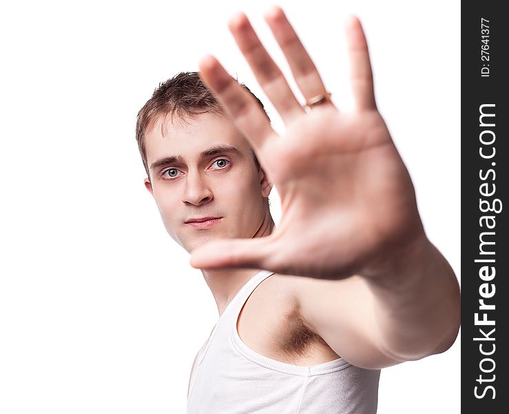 Portrait of a young man looking out from under raised hand on a white background