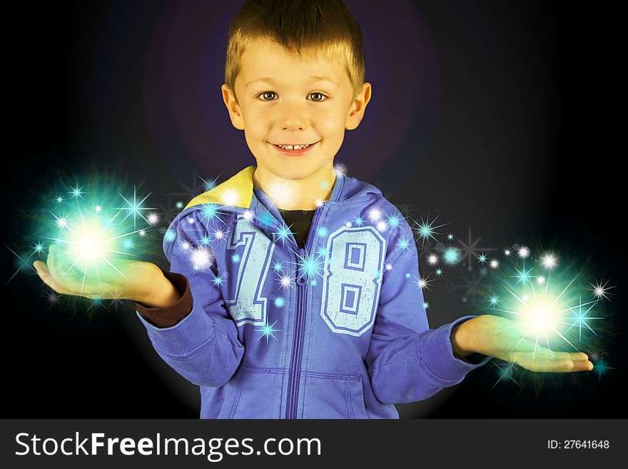 Male magician child with stars; Young male child creating magic with stars and a black background. Male magician child with stars; Young male child creating magic with stars and a black background.