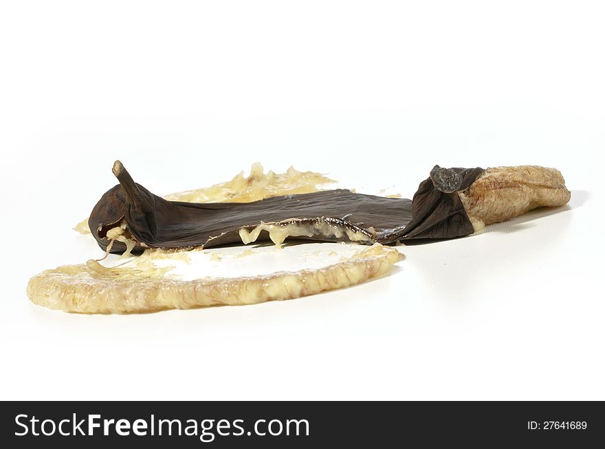 Closeup of smashed over ripe black banana on white. Closeup of smashed over ripe black banana on white