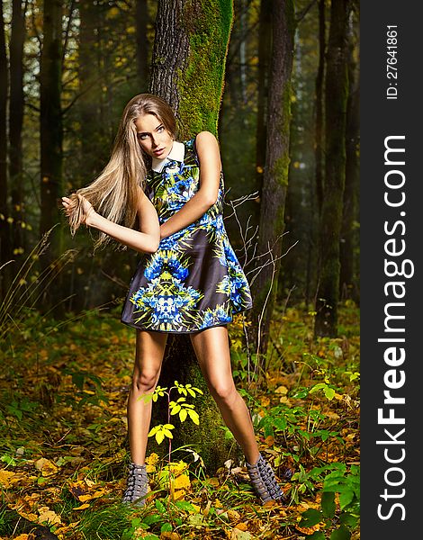 Fashion portrait of young beautiful woman posing in nature