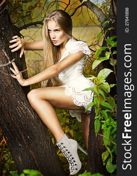 Fashion portrait of young beautiful woman posing in nature