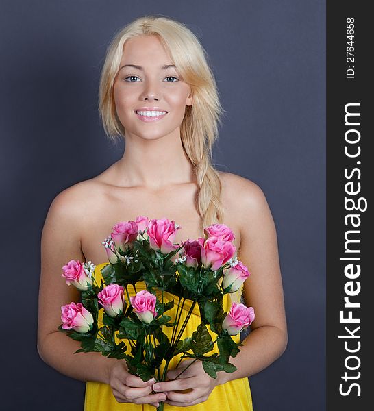 An portrait of a pretty young woman smiling and holding flowers. An portrait of a pretty young woman smiling and holding flowers