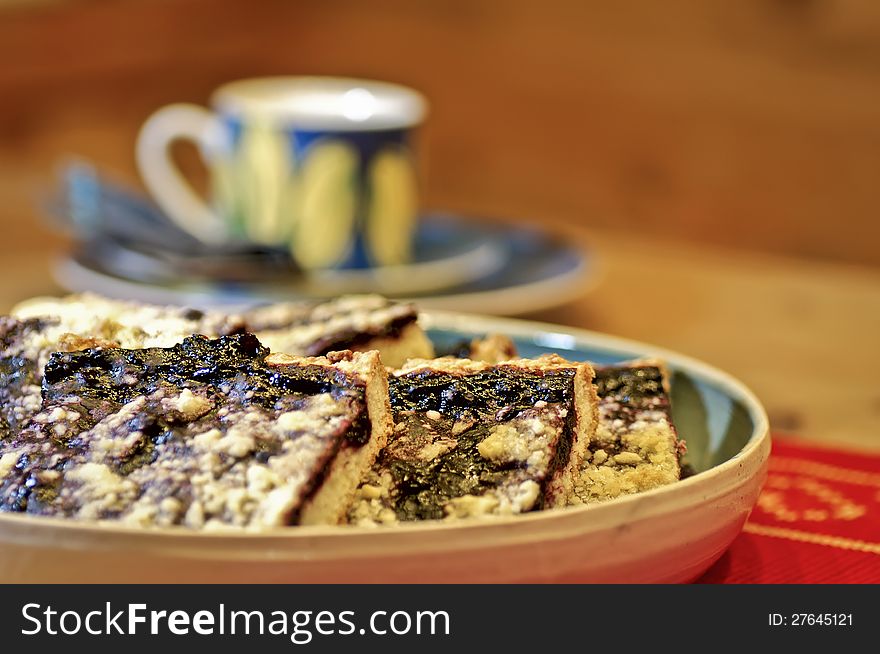 Blueberry pie slices and a defocused coffee cup.