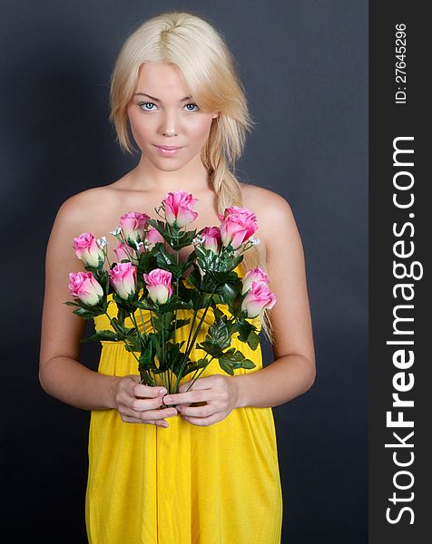 An image of a sweet young woman shyly holding a bouquet of pink flowers. An image of a sweet young woman shyly holding a bouquet of pink flowers