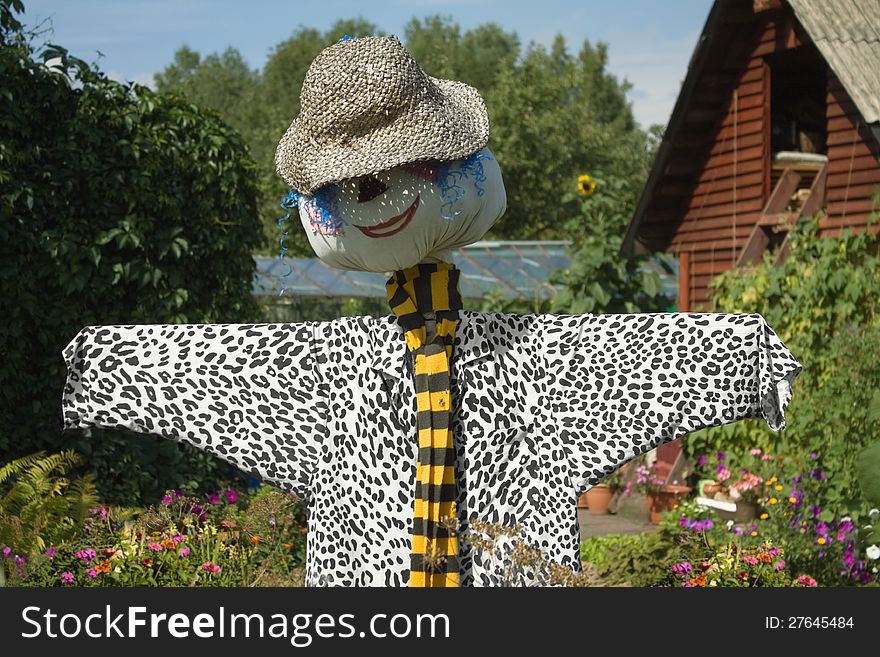 Smiling scarecrow in the summer garden. Smiling scarecrow in the summer garden