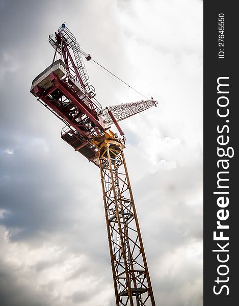 Yellow Tower Crane On Building Top With Blue Sky