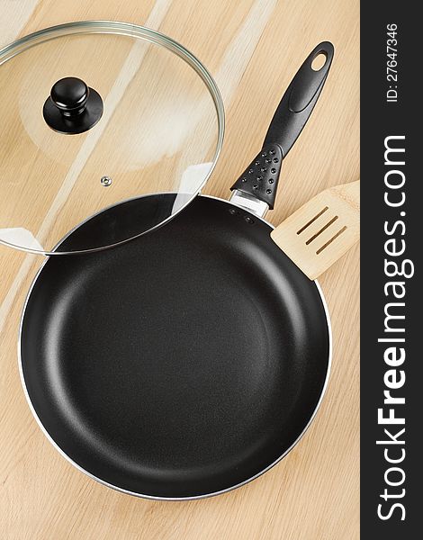 Frying pan with lid on wooden table. Frying pan with lid on wooden table