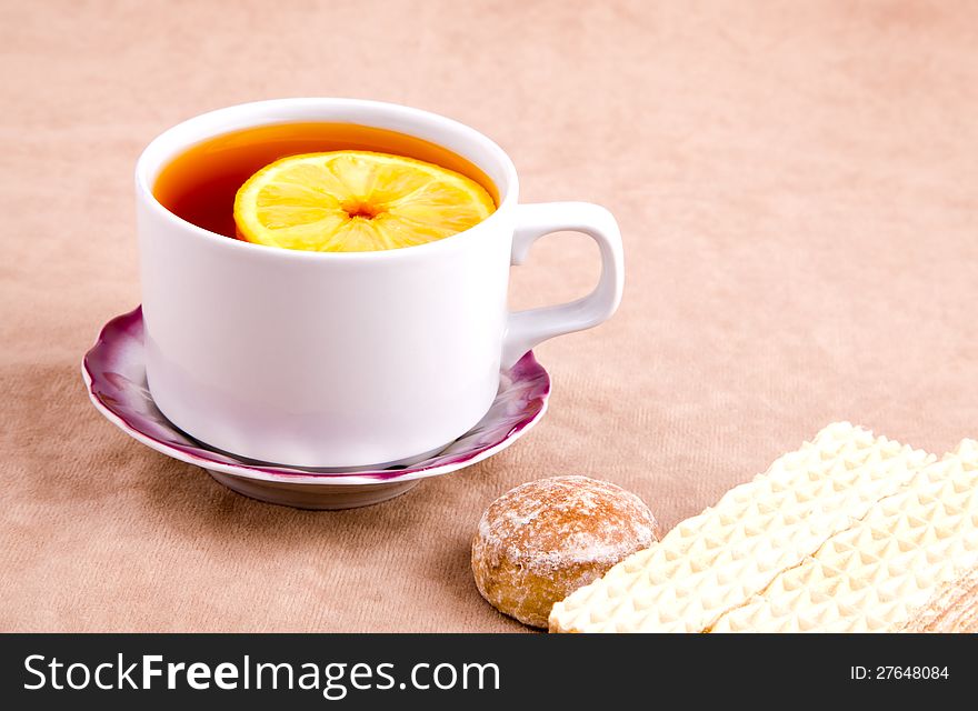 Tea with Lemon and sweet treats on the background of suede