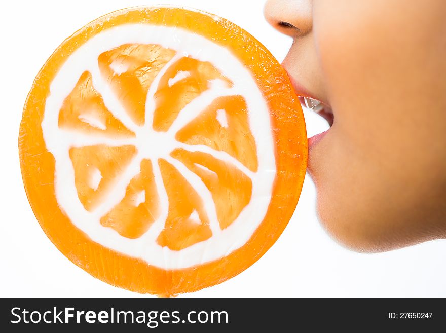Closeup shot of little girl with orange lollipop ,Isolated over white