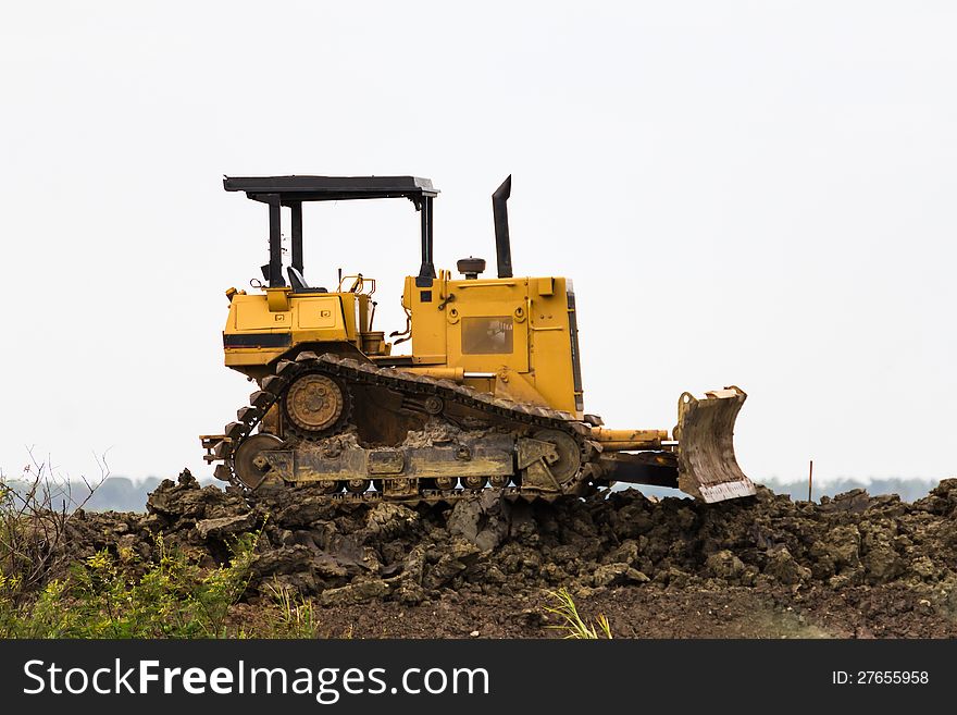 Bulldozer machine doing earth moving work in construction site. Bulldozer machine doing earth moving work in construction site