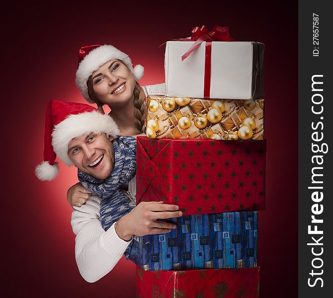 Young Couple In Santa Hats With Presents Isolated