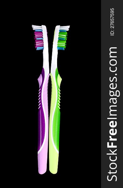 Pair of colorful toothbrushes on black background