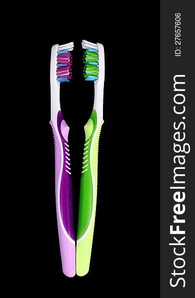 Pair of colorful toothbrushes on black background