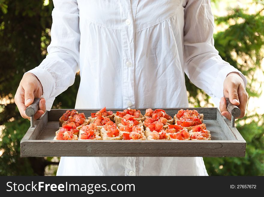 Waitress holding a plate with Italian bruschetta. Waitress holding a plate with Italian bruschetta