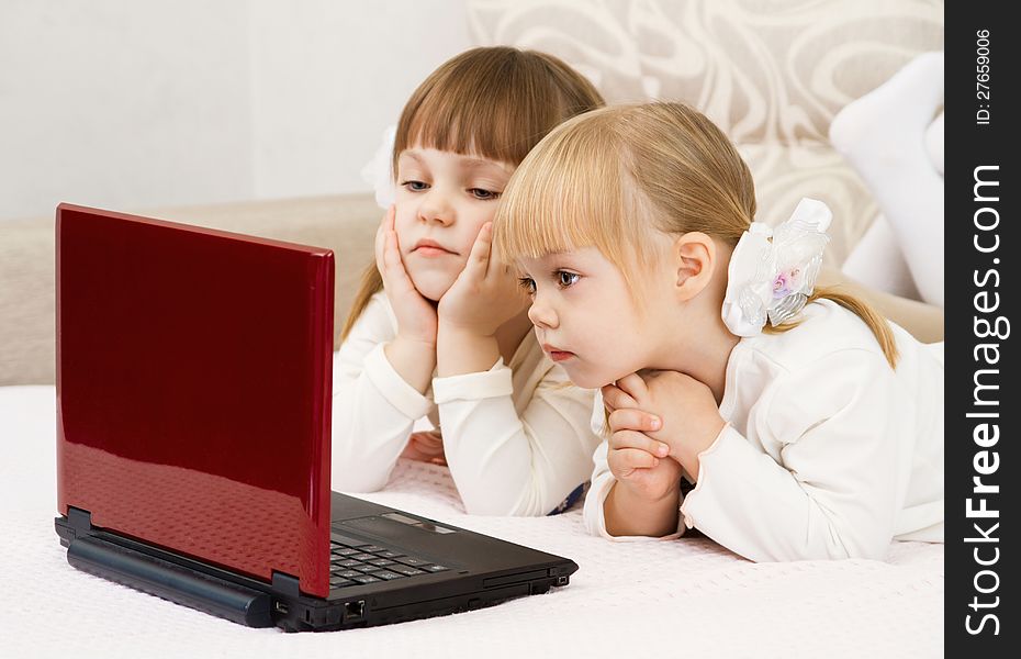 Two little girls are with a laptop and a credit card