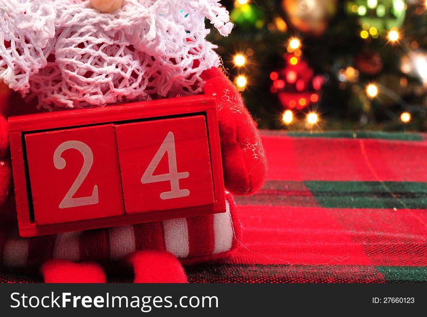 Red box with calendar date and christmas tree in the background . Red box with calendar date and christmas tree in the background .