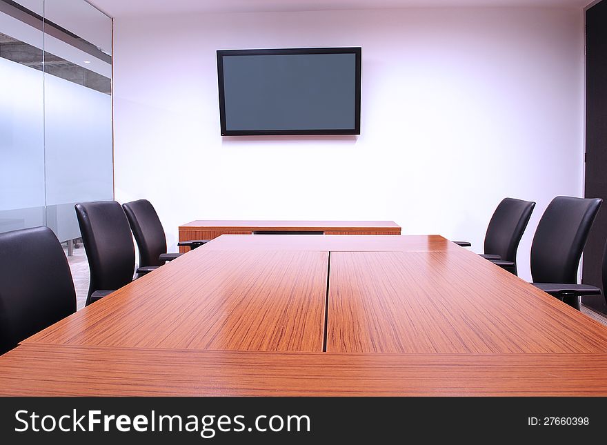 Furnished meeting room with display on wall. Furnished meeting room with display on wall.